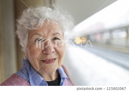 Portrait of smiling senior woman waiting at train station Portrait of smiling senior woman waiting at train station 123802067