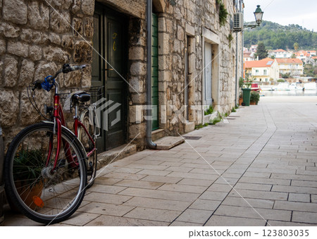 Bicycle leaning against an old stone house. Promenade in the background Bicycle leaning against an old stone house. Promenade in the background 123803035