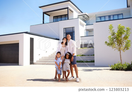 Portrait, real estate and happy family moving into their new luxury home, house or property in summer. Happy parents and children standing with a smile outdoor with building investment or purchase 123803213
