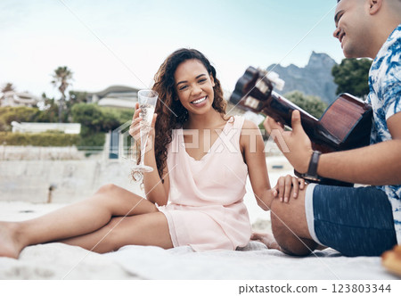 Happy couple, guitar and love on a beach together playing a romantic, love or bonding music for woman. Portrait romance, happy young man and woman play acoustic instrument or laugh outdoor on sand Happy couple, guitar and love on a beach together playing a romantic, love or bonding music for woman. Portrait romance, happy young man and woman play acoustic instrument or laugh outdoor on sand 123803344