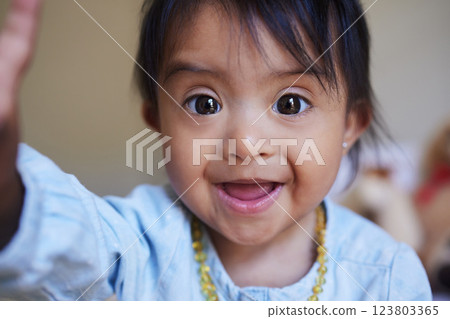 Children, down syndrome and selfie with a girl taking a photograph while looking cute or adorable. Kids, disability and picture with a young female child posing for a self portrait alone in her home 123803365