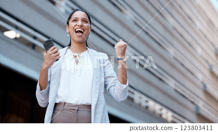 Phone, success celebration and woman in city after winning, deal or receiving startup funding. Wow, winner and Indian female excited, victory or celebrating financial goals, mission or sales targets. 123803411