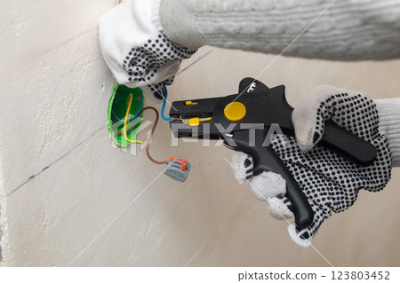 Installing electrical wiring during construction. 123803452