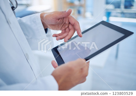 Hands, tablet and healthcare with a doctor doing research with a search on the internet for insurance or medical innovation. Health, medicine and analytics with a male surgeon working in a hospital 123803529