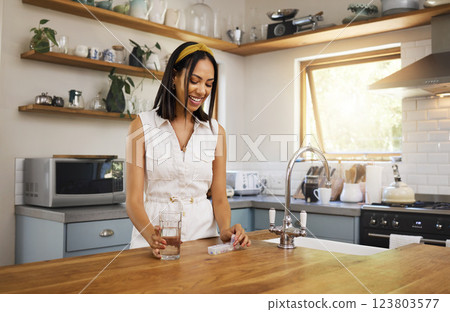 Woman drink medicine pills with a glass of water or supplement capsule in her kitchen apartment. Latino female in recovery with a pill or medical prescription drug for health, wellness or energy Woman drink medicine pills with a glass of water or supplement capsule in her kitchen apartment. Latino female in recovery with a pill or medical prescription drug for health, wellness or energy 123803577