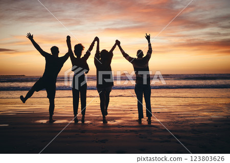 Silhouette, sunset and friends holding hands at the beach on holiday in Miami during summer. Group of people with support, community and calm on a vacation by the water and sea for peace in nature 123803626