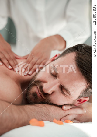 Zen spa, man and shoulder massage in luxury healthcare clinic, wellness beauty salon or peace room for relax sleep on table bed. Zoom, people or cosmetic therapist or masseuse oil hands for self care Zen spa, man and shoulder massage in luxury healthcare clinic, wellness beauty salon or peace room for relax sleep on table bed. Zoom, people or cosmetic therapist or masseuse oil hands for self care 123803838