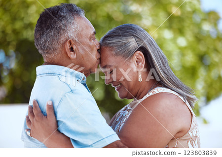 Elderly, couple and happy with love, hug and kiss on face in backyard, garden or park together in summer. Man, woman and retirement show romance, bonding and care in nature, smile and embrace 123803839