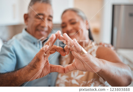 Hands, heart and love with a senior couple in their retirement home together for health, wellness and romance. Fingers, sign and affection with a mature man and woman pensioner bonding in their house 123803888