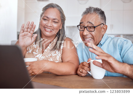 Laptop, video call and senior couple wave at friends and family while drinking coffee together at a table. Lockdown, communication and elderly man and woman enjoy online conversation in their home 123803899