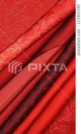 A collection of rich red fabrics showcasing various textures and patterns. 123805396