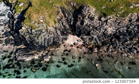 Aerial drone shot above a rocky, secret sandy beach with clear water Aerial drone shot above a rocky, secret sandy beach with clear water 123807384