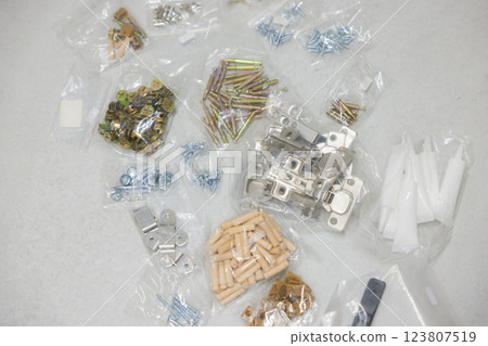 一名男子正在組裝有許多零件的家具 一名男子正在組裝有許多零件的家具 123807519