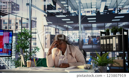 African american businesswoman searching for commercial office spaces, doing a blueprints review and drafting building layouts to find the perfect property. Investment strategy real estate. Camera B. African american businesswoman searching for commercial office spaces, doing a blueprints review and drafting building layouts to find the perfect property. Investment strategy real estate. Camera B. 123807919