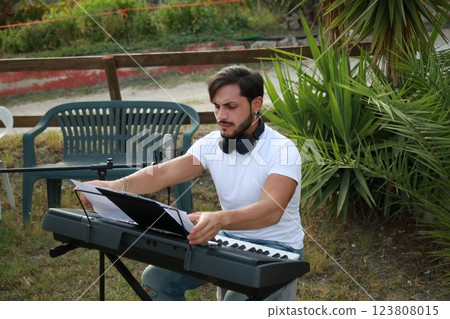 Boy Pianist Plays The Keyboard In An Outdoor Garden For A Private Party 123808015