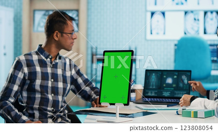 Specialist discussing x ray imaging with a patient next to isolated mockup display, presenting healthcare diagnosis during check up visit. Physician sharing the treatment plan and advice. Camera A. 123808054