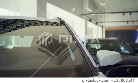 Exterior detail close up of steel white car body door post, windows, and driver chair inside. Panning shot of parked vehicle and leather black seat in automobile interior 123808147