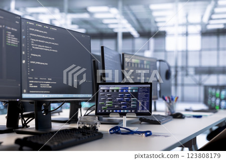 Computers in data center hosting rackmount ensuring faultless operations conditions. Close up of PC monitors and tablet on desk used for monitoring data center devices energy consumption 123808179
