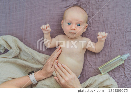 A mother gently massages her 1-month-old baby with baby oil after a bath. This tender moment highlights the bond between parent and child, promoting relaxation, baby care, and the importance of skin A mother gently massages her 1-month-old baby with baby oil after a bath. This tender moment highlights the bond between parent and child, promoting relaxation, baby care, and the importance of skin 123809075