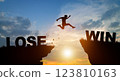 Silhouette man jumping from LOSE to WIN wording on cliffs with cloud sky and sunrise. Never give up and Business Concept. 123810163