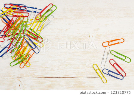 Colorful paper clips | Wood grain background 123810775