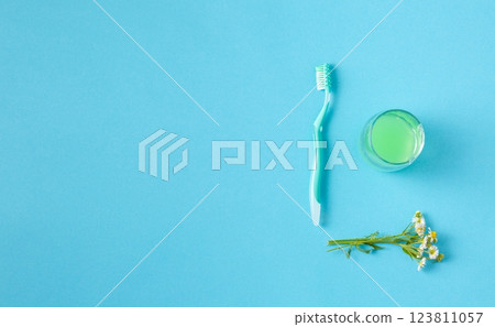 Mouthwash in a glass and a toothbrush. 123811057