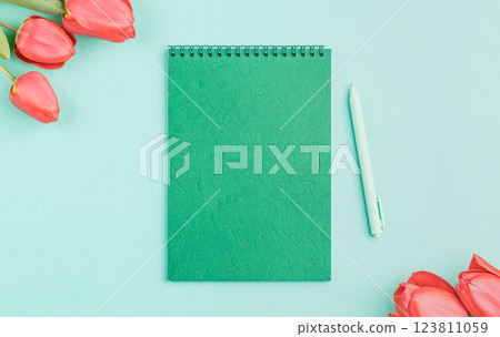 Green notebook with a pen and flowers. Green notebook with a pen and flowers. 123811059