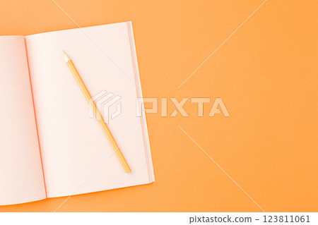 Pink sketchbook with colored pencils. 123811061