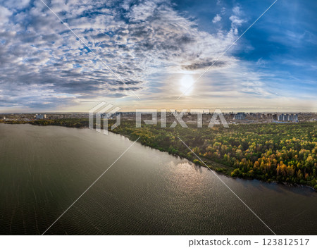 Autumn forest on lake shore at sunset and city on horizon, auerial view Autumn forest on lake shore at sunset and city on horizon, auerial view 123812517