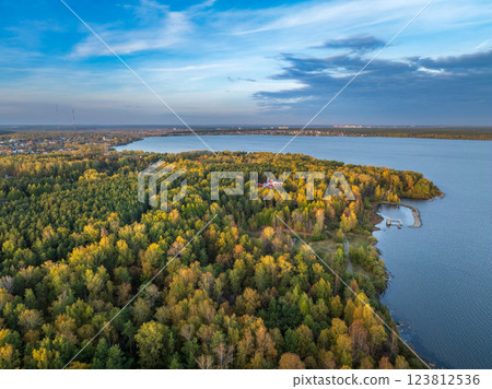 Autumn forest on lake shore at sunset and city on horizon, auerial view Autumn forest on lake shore at sunset and city on horizon, auerial view 123812536