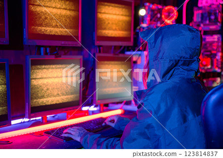 Woman hacker wear hood sit front computer typing on keyboard hacking servers in neon light, Gamer woman streaming game online dark room, Female hacker breaks into data center, Blockchain cyberattack Woman hacker wear hood sit front computer typing on keyboard hacking servers in neon light, Gamer woman streaming game online dark room, Female hacker breaks into data center, Blockchain cyberattack 123814837