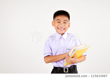 Portrait smile Asian little boy primary posing hand holding book studio isolated white background, happy cute man kid wear school uniform plaid, back to school concept Portrait smile Asian little boy primary posing hand holding book studio isolated white background, happy cute man kid wear school uniform plaid, back to school concept 123814987