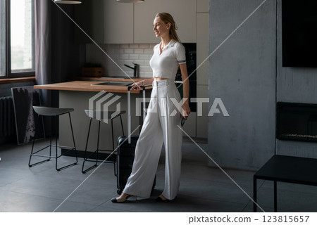 Woman returned home from vacation with a suitcase 123815657