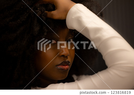 Portrait of a woman with natural hair in a white outfit, exuding elegance and confidence Portrait of a woman with natural hair in a white outfit, exuding elegance and confidence 123816819