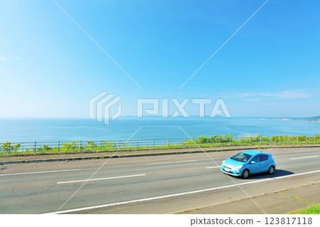 北海道：行駛在藍天和海邊公路上的汽車 123817118