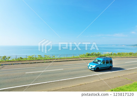 北海道：行駛在藍天和海邊公路上的汽車 123817120