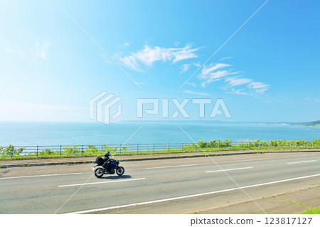 Hokkaido: Motorcycle running along the road along the sea against the blue sky Hokkaido: Motorcycle running along the road along the sea against the blue sky 123817127