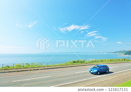 Hokkaido: A car running on the blue sky and the seaside road Hokkaido: A car running on the blue sky and the seaside road 123817131