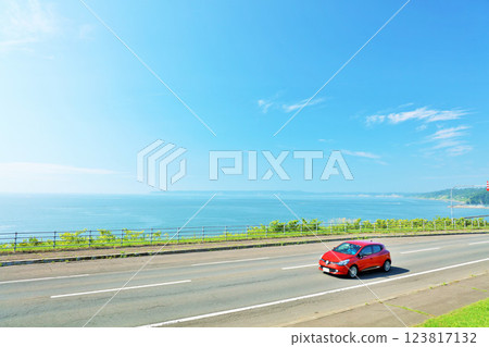 北海道：行駛在藍天和海邊公路上的汽車 123817132