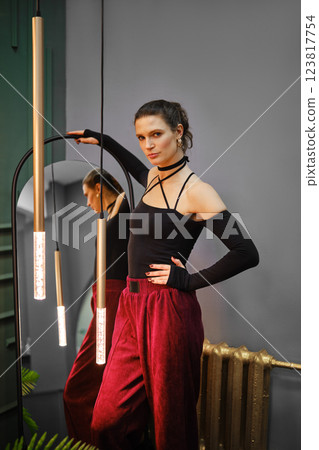 Woman standing by the mirror in living room Woman standing by the mirror in living room 123817754
