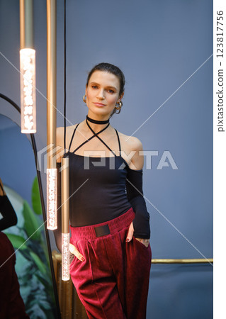 Stylish woman posing in modern interior with trendy lighting and fashion-forward outfit Stylish woman posing in modern interior with trendy lighting and fashion-forward outfit 123817756