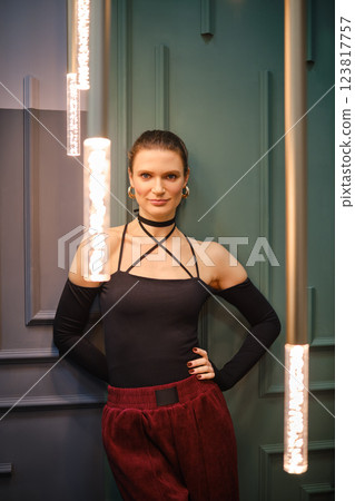 Cheerful woman poses gracefully in a trendy outfit against a stylish contemporary backdrop Cheerful woman poses gracefully in a trendy outfit against a stylish contemporary backdrop 123817757
