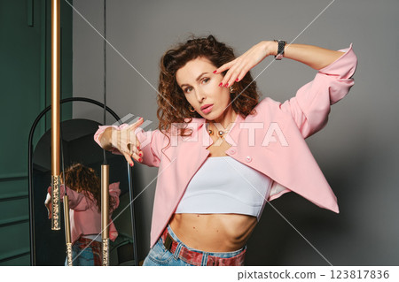 Pretty woman poses confidently in stylish outfit against modern backdrop Pretty woman poses confidently in stylish outfit against modern backdrop 123817836