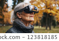 Elderly woman enjoying virtual reality in autumn park ai generative 123818185