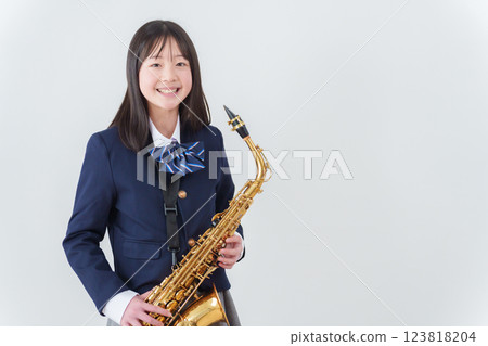 銅管樂隊中一名女學生正在吹奏薩克斯風 123818204