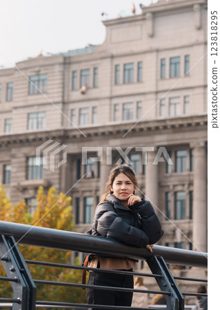 woman traveler visiting in Shanghai, China. Happy Female Tourist sightseeing Shanghai view in The Bund of Shanghai in Autumn season. landmark and popular for tourism attractions. Travel and Vacation 123818295