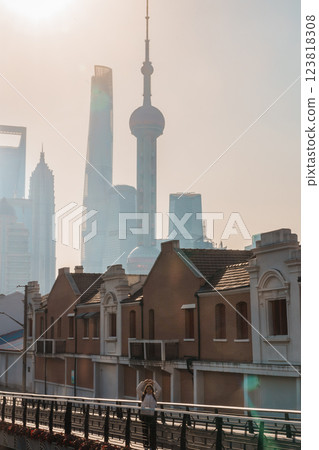 woman traveler visiting in Shanghai, China. Female Tourist with backpack sightseeing Shanghai view of Lujiazui in Hongkou Gang canal of Shanghai. landmark and popular for tourism attraction 123818308