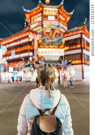 woman traveler visiting in Shanghai, China. Happy Female Tourist sightseeing and shopping in Yuyuan Old Street market at night. landmark and popular for tourism attractions. Travel and Vacation 123818314
