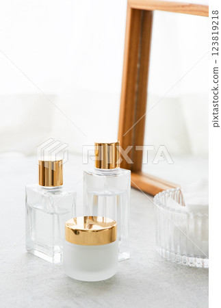 A wooden framed mirror and skincare products placed by the window 123819218