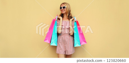 Fashion, clothing. Stylish beautiful happy woman with colorful shopping bags in summer dress Fashion, clothing. Stylish beautiful happy woman with colorful shopping bags in summer dress 123820660